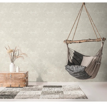 Woonkamer met patroonbehang, hangstoel en decoratie