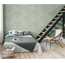 Slaapkamer met bed, ladder en behang met bladmotief