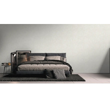 Slaapkamer met bed, nachtkastje en behang met patroon voor een rustige sfeer