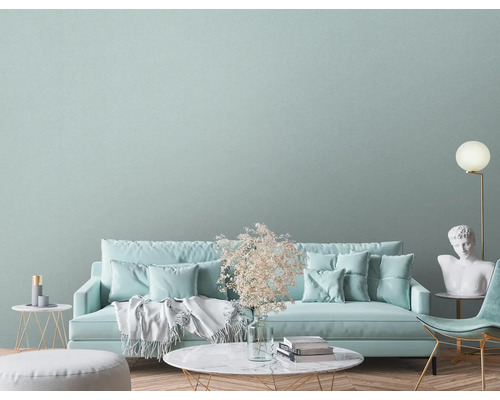 Lichte woonkamer met bank, fauteuil, vloerlamp en decoraties