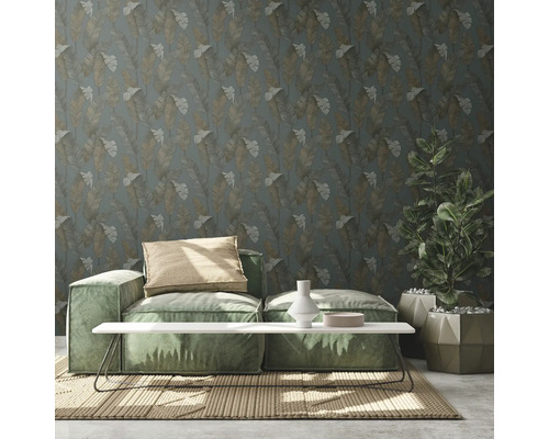 Woonkamer met groene bank, tafel, potplant en behang met bloemmotief