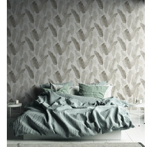 Slaapkamer met bed en behang met bladerenmotief