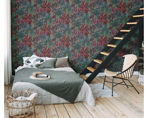 Slaapkamer met bed, stoel en wandbekleding met plantmotief
