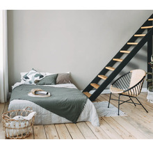 Slaapkamer met bed, ladder, rotan stoel en wasmand