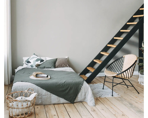 Slaapkamer met bed, ladder, rotan stoel en wasmand