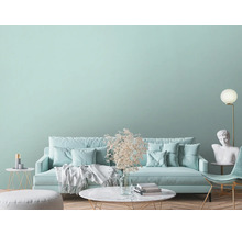 Woonkamer met bank, fauteuil, tafel, staande lamp en decoraties voor een heldere en georganiseerde sfeer.