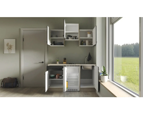 Compacte keuken met spoelbak, kookplaat en koelkast in een lichte ruimte.