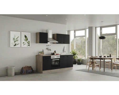 Moderne keuken met kasten, fornuis, afzuigkap en eettafel in een lichte ruimte.