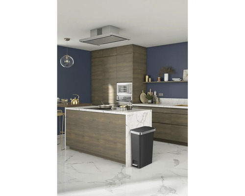 Keuken met vrijstaand kookeiland, afzuigkap en een zwarte afvalemmer met pedaal