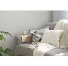 Grijze bank met kussens, deken en houten tafel