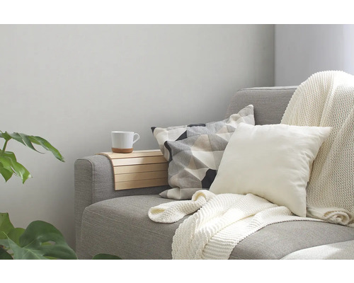 Grijze bank met kussens, deken en houten tafel