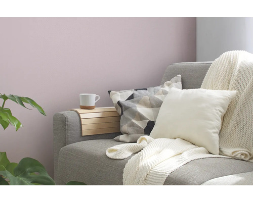 Woonkamer met grijze bank, kussens, plaid en houten tafel