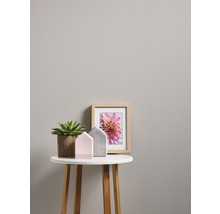 Close-up van een subtiel patroonbehang dat dient als achtergrond voor een tafel met decoratie