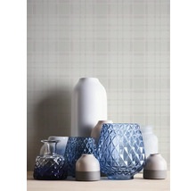 Diverse decoratieve vazen op een tafel voor een wand met motief