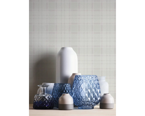 Diverse decoratieve vazen op een tafel voor een wand met motief