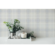 Decoratieve scène met geruit behang, eucalyptus in een kruik, kaars en decoratiehaas op een dienblad