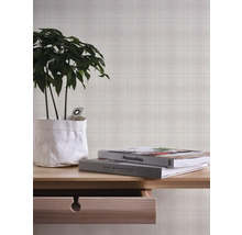 Decoratieve scène met tafel, kamerplant, boeken en patroonbehang voor een stijlvolle leefomgeving.