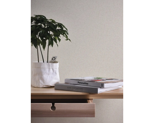 Decoratief interieur met patroonbehang, plant en boeken op een houten tafel