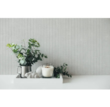 Decoratie met eucalyptus, kaars en decoratief figuur op een dienblad voor een gestreept behang