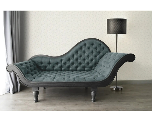 Chaise longue met knoopsluiting en staande lamp in een lichte kamer.