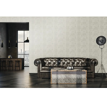 Woonkamer met leren bank, salontafel en patroonbehang