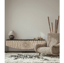 Woonkamerinterieur met een gestreepte fauteuil, dressoir, lamp en vloerkleed voor een gezellige sfeer.