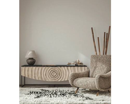 Woonkamerinterieur met een gestreepte fauteuil, dressoir, lamp en vloerkleed voor een gezellige sfeer.