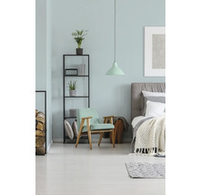 Slaapkamer met bed, fauteuil, rek en lamp