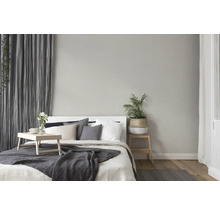 Licht ingerichte slaapkamer met bed, nachtkastje, gordijnen en decoraties