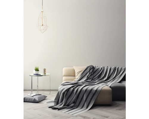 Woonkamer met bank, deken, bijzettafel en lamp