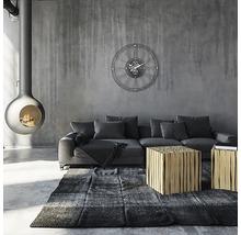 Woonkamer met open haard, bank, vloerkleed, tafel en wandklok