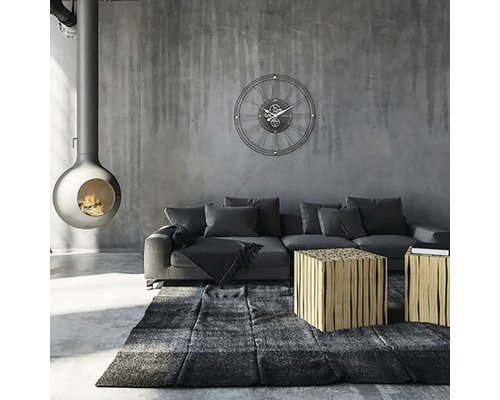 Woonkamer met open haard, bank, vloerkleed, tafel en wandklok