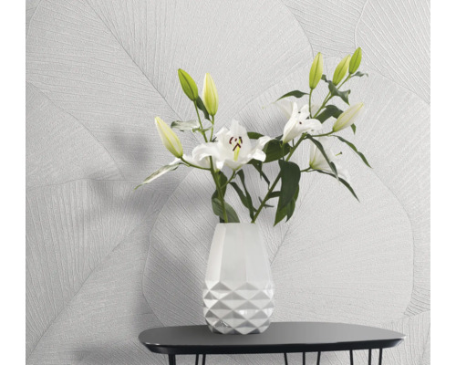 Licht, vriendelijk interieur met patroonbehang en een bloemenvaas op een tafel