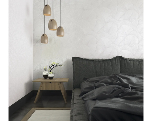 Slaapkamer met bed, nachtkastje, lamp en behang met patroon