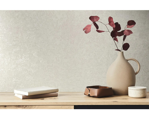 Decoratieve elementen zoals een vaas, boeken en schalen op een tafel voor een gestructureerde wand.