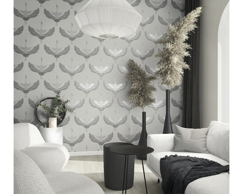 Lichte woonkamer met behang met kraanvogelmotief, bank, tafel en decoraties