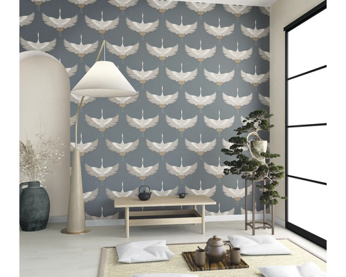 Lichte kamer met behang met vogelmotief, vloerlamp, kleine tafel en kamerplant.