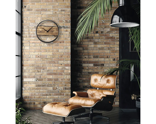 Woonkamer met bakstenen muur, fauteuil en wandklok