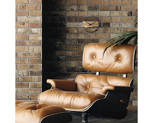 Kameroverzicht met lederen fauteuil, voetenbank en wandklok tegen een bakstenen muur.