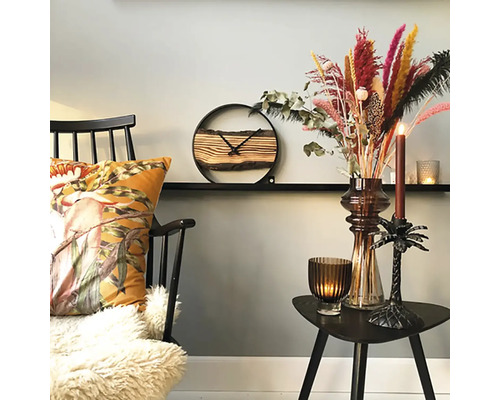 Decoratieve woonsfeer met stoel, kussen, klok, droogbloemen en kaarsen