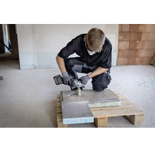 Ambachtsman met accu haakse slijper aan het werk aan een plaat