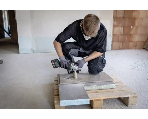 Ambachtsman met accu haakse slijper aan het werk aan een plaat