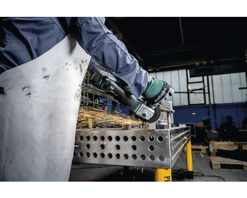 Persoon die metaal slijpt met een Metabo haakse slijper