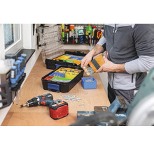 Werkbank met assortimentsdozen, schroeven en accuschroevendraaier