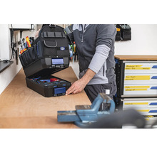 Geopende gereedschapstas met gereedschap op een werkbank