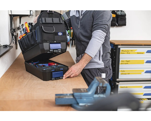 Geopende gereedschapstas met gereedschap op een werkbank