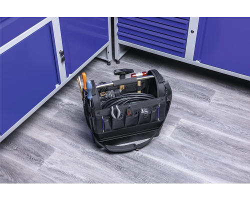 Geopende gereedschapstas gevuld met gereedschap voor blauwe werkplaatskasten