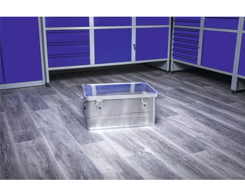 Aluminium gereedschapskist op een werkplaatsvloer voor blauwe gereedschapskasten