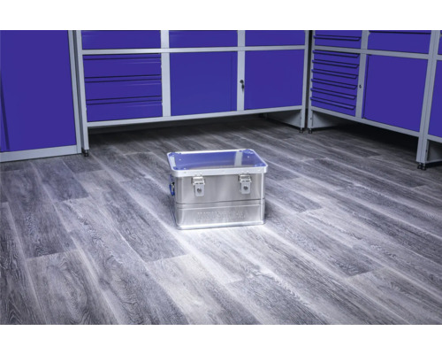 Aluminium gereedschapskist op de vloer voor blauwe werkplaatskasten