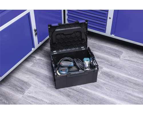 Geopende gereedschapskist met elektrisch gereedschap voor blauwe metalen kasten